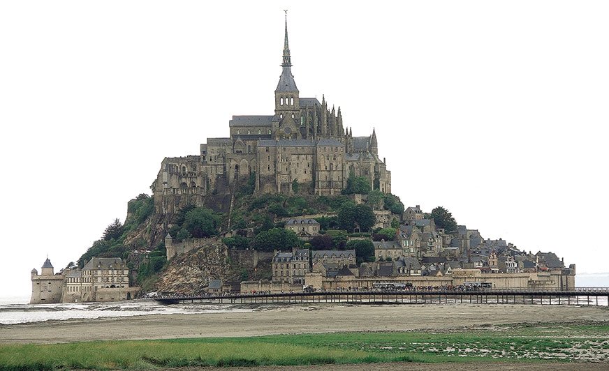Mont Saint-Michel. Jest to bardzo stare opactwo wraz z miasteczkiem, wybudowane na wyspie, które z lądem połączone jest wąską groblą, ale tylko w czasie silnych przypływów.
