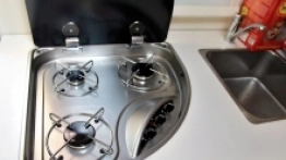 Trzypalnikowa kuchenka sprawdza się, szczególnie gdy w kamperze zamieszkuje 5 osób. Obok lodówka, zlew i szuflada na sztućce - zdjęcie 16