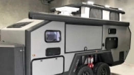 Bruder EXP-6 na postoju, z podniesionym dachem. U góry widoczna zwinięta markiza, którą można rozwinąć nad kuchnią i prysznicem, gdy zdecydujemy się korzystać z nich na zewnątrz - zdjęcie 8