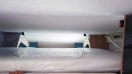 Układ mebli w kamperze jest dość standardowy dla modeli półzintegrowanych.  Z tyłu sypialnia z zamykanymi drzwiami, a nad stolikiem drugie łóżko opuszczane - zdjęcie 3