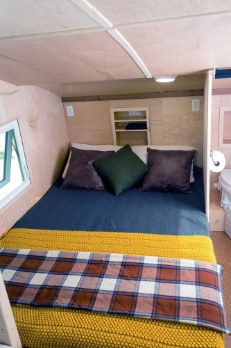 Duże, dwuosobowe łóżko w przedniej części przyczepy. Obok, za ścianką, widoczna toaleta - zdjęcie 3
