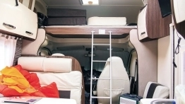W wejściu na alkowę pomaga wytrzymała drabinka. Szkoda, że producent nie zastosował kurtyny oddzielającej część mieszkalną od szoferki - zdjęcie 21