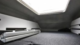 13. Górne łóżko nad szoferką rozkłada się w łatwy sposób, ale przestrzeni starczy tam najwyżej dla dzieci lub jednej osoby dorosłej - zdjęcie 14