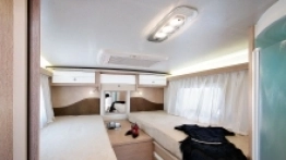 Duża sypialnia z możliwością swobodnej konfiguracji łóżek, całkiem przestronne szafy i ciekawe podświetlenie LED nadające charakter temu kamperowi - zdjęcie 2