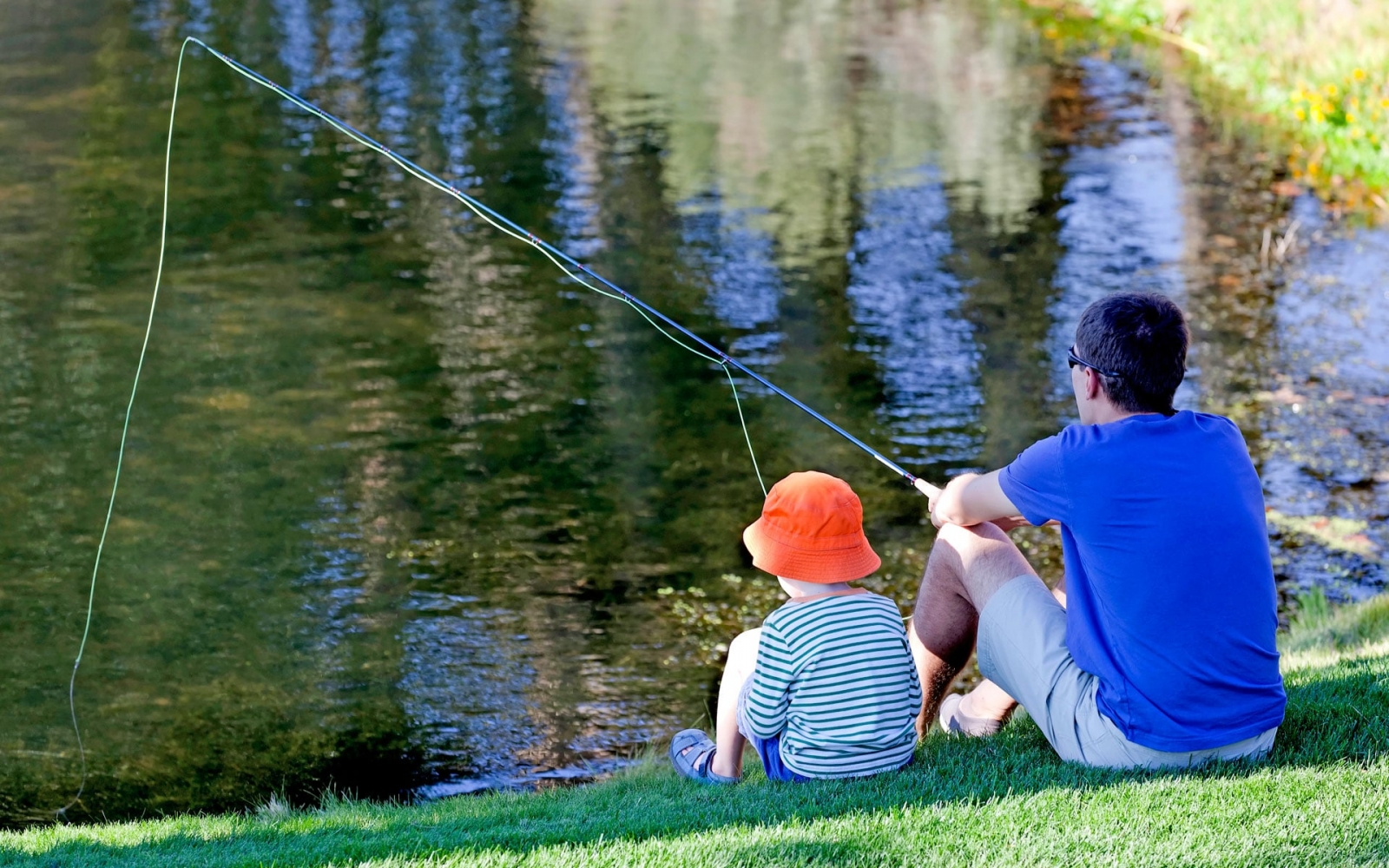Сын ловит рыбу. Отец и сын на рыбалке. Мальчик с папой на рыбалке. Семья на рыбалке. Папа Рыбак.