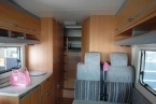                         wnętrze, salon, kanapa, aneks kuchenny, kuchnia,blat roboczy, miejsca siedzące, Przyczepa kempingowa , kemping, kamping, cemping, camping, kampery, campery, camper, kamper 
                        